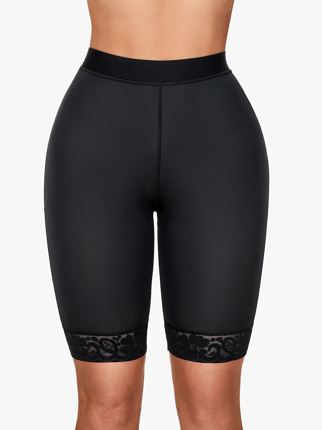Seamless black sports shorts with elegant lace trim and supportive high waistband for stylish shaping.
